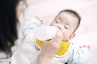 Asyalı bebek uyurken süt içiyor