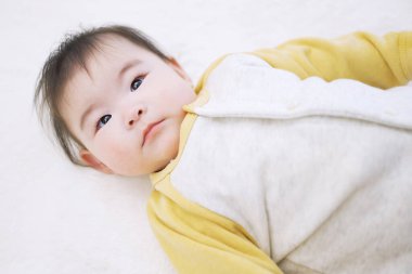 Uyandığında ciddi bakışları olan Asyalı bebek.