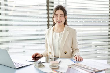 Asian female architect standing at a design office