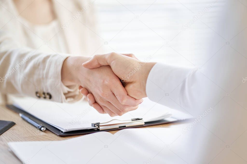Asian business person who closes a business and shakes hands