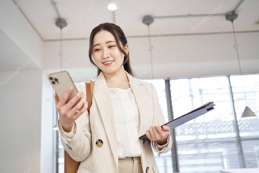 Asian business woman checking schedule with smartphone