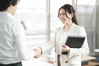 Erkek ve kadınların Asyalı iş adamı el sıkışıyor