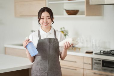 Asyalı kadın havluları katlayıp kaldırıyor.
