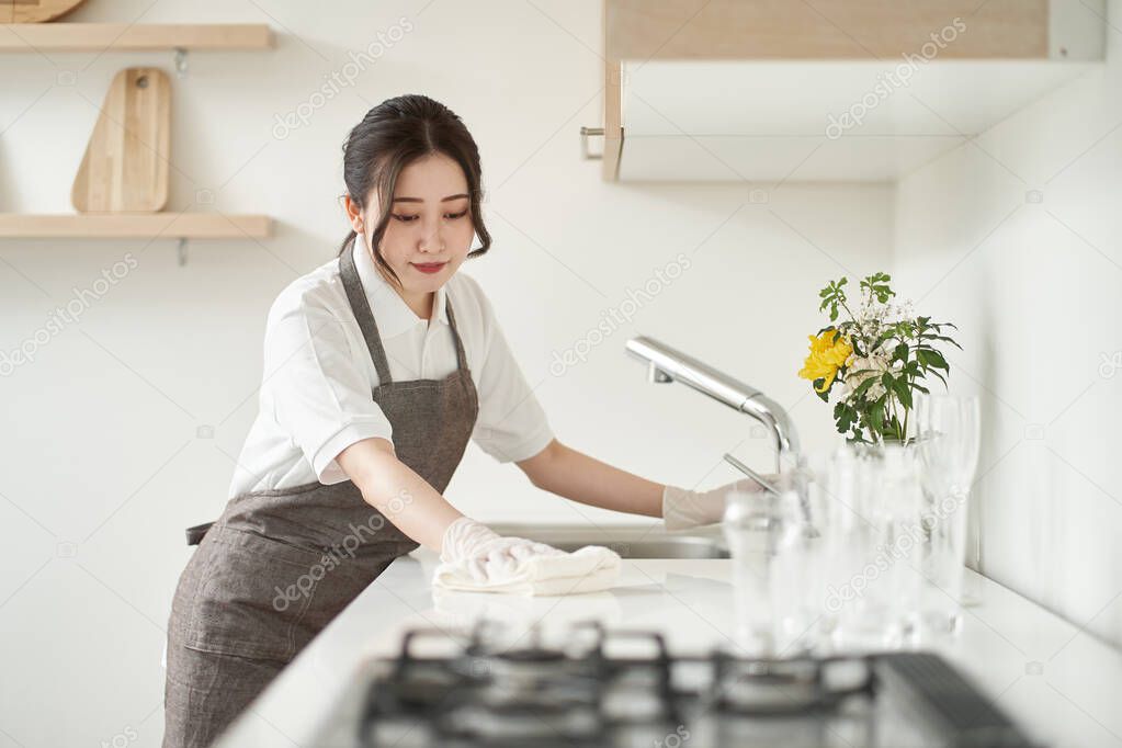 Asian woman wiping the kitchen