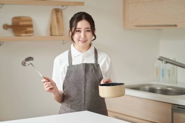 Mutfakta yemek yapan Asyalı kadın.