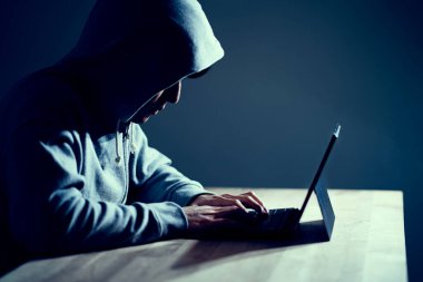 Erkek hacker dizüstü bilgisayarda kod yazıyor.