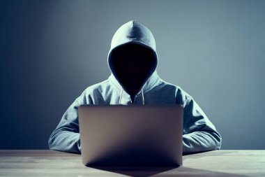 Erkek hacker dizüstü bilgisayarda kod yazıyor.