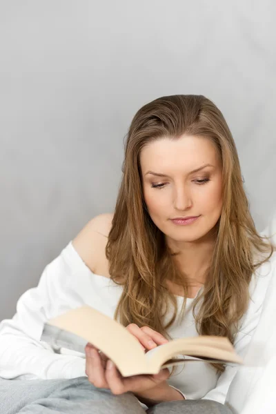 Frau liest Buch zu Hause und entspannt — Stockfoto