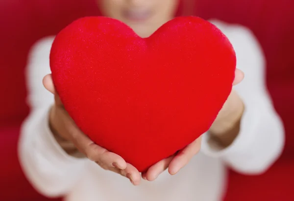 Beautiful woman holding heart in hand - care and love — Stock Photo, Image