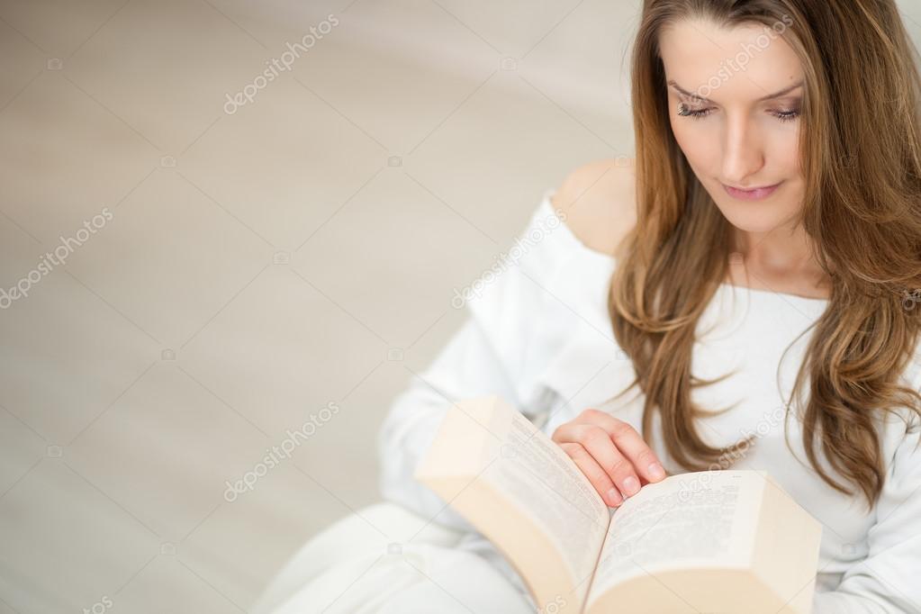 Woman reading a book and relaxing on sofa