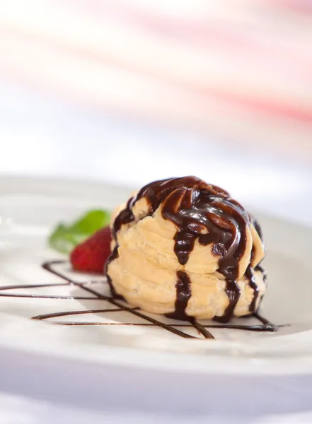 Choklad profiteroles med glass på en tallrik — Stockfoto