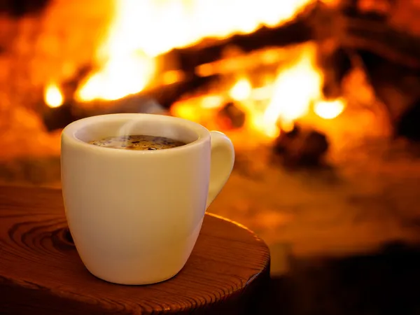 Hot smoking coffee by fireplace — Stock Photo, Image