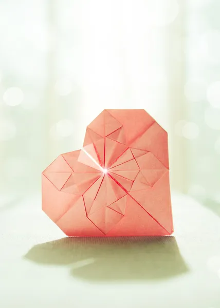 Imagen estilizada de un corazón de origami de papel con luz de fondo y sombra — Foto de Stock