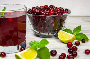 Yaban mersinli mors, beyaz ahşap bir masada nane ve limon.