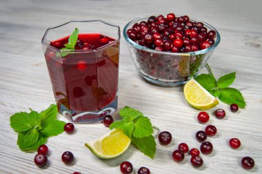 Yaban mersinli mors, beyaz ahşap bir masada nane ve limon.