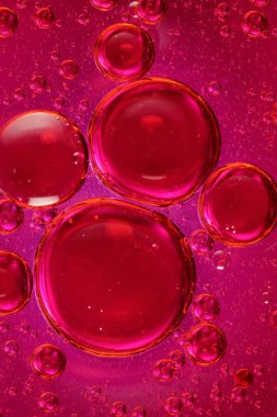 Renkli bir zemin üzerinde su bulunan yağ kabarcıkları