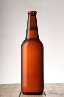 Beyaz arka planda tam kahverengi bira şişesi.