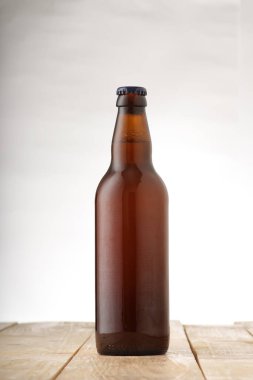 Beyaz arka planda biralı kahverengi şişe.