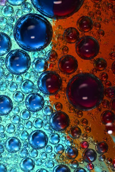 Renkli bir zemin üzerinde su bulunan yağ kabarcıkları