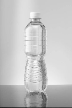 Gri arka planda renksiz küçük bir şişe.