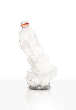 Beyaz arka planda ezilmiş plastik soda şişesi.