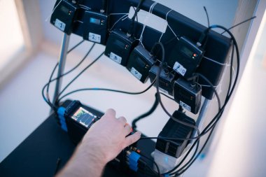 Sette mikrofonu olan ses mühendisi. Profesyonel bir ses mühendisi, bir film, ticari ya da televizyon dizisinin çekimlerinde çalışıyor. İçerideki çekim süreci, stüdyo.