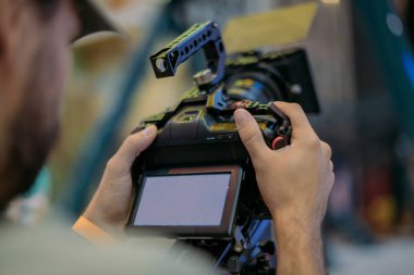 Profesyonel sinema ve video kamera sette. Atış vardiyası, aydınlatma aletleri, çekim ekipmanları ve ekip. Modern film ve reklam teknikleri..