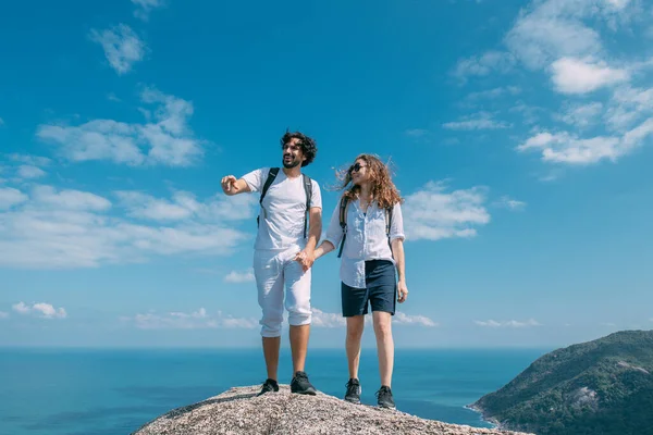 Okyanusun destansı manzarasına sahip bir çift kayanın üzerinde duruyor. Popüler bir turizm merkezi. Sevgililer tropik bölgelerde tatildeler. Tropiklerde balayı.