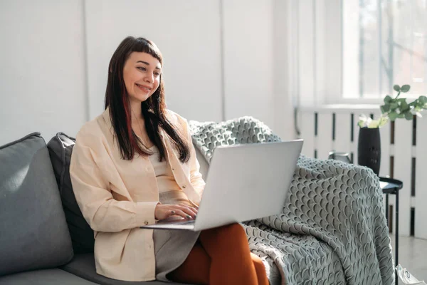 Young Woman Works Laptop Communicates Online Modern Bright Office Sofa — Stock Photo, Image