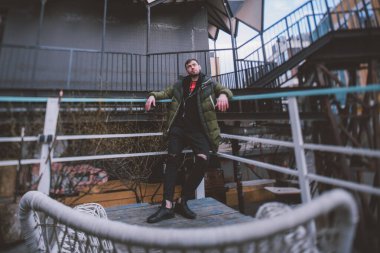 Modern bir geometrik mekanda şık giyinmiş genç bir adam. Modern insanın görüntüsü. Şehir caddesinde ceketli yakışıklı esmer bir adamın portresi..