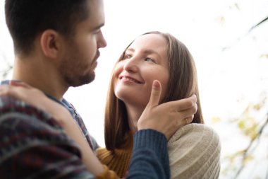Sevgili bir çiftin randevudaki portresi. Yakın plan. Genç yakışıklı bir adam kız arkadaşına sarılıyor, yüzünü okşuyor, onu öpüyor..