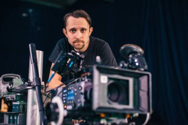 Görüntü yönetmeni elinde kamerayla sette. Bir film, ticari ya da televizyon dizisi çekmek için çalışan profesyonel bir videograf. İçerideki çekim süreci, stüdyo.