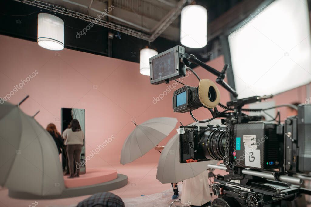 A professional film and video camera on the set. Filming day, equipment and crew. Technique of modern video filming.