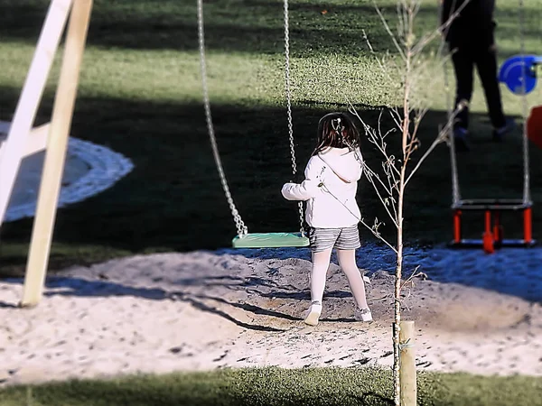 公園で遊んでいる白いジャケットの少女 — ストック写真