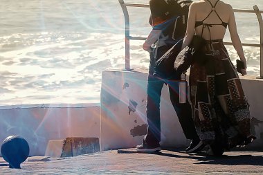 Atlantik kıyısında güneşli bir kış gününün tadını çıkaran turistler