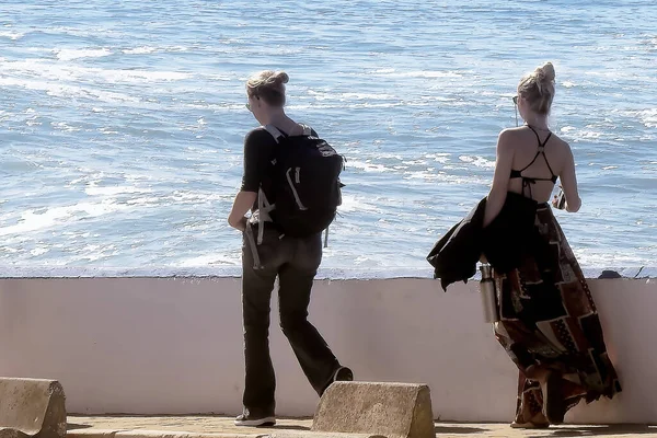 Atlantik kıyısında güneşli bir kış gününün tadını çıkaran turistler