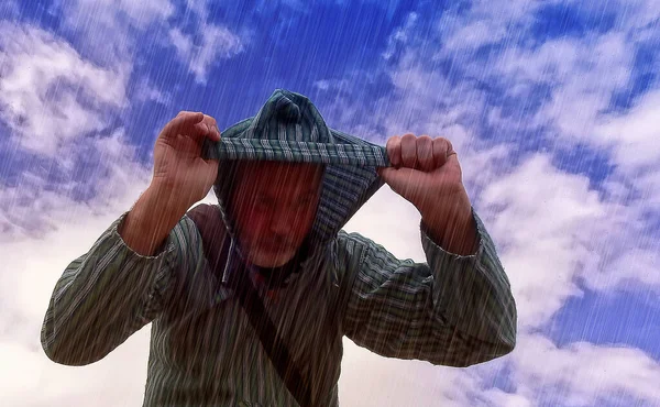 头戴头巾的人在雨中保护自己 — 图库照片