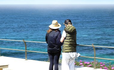 Deniz kenarında denize bakan iki kadın.