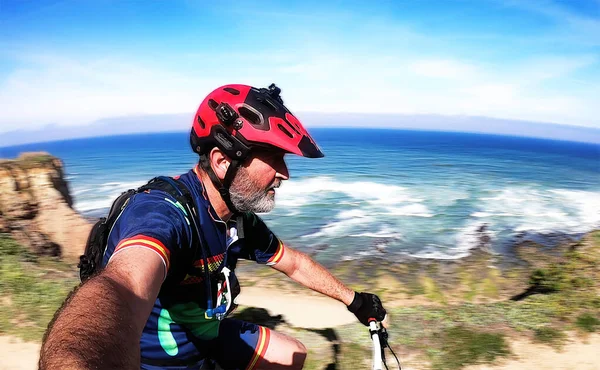 Ciclista Com Capacete Vermelho Engrenagem Azul Pedalando Perto Oceano — Fotografia de Stock