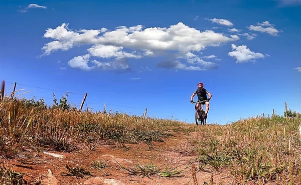 Cyclist Blue Gear Pedaling Field Blue Sky — Stockfoto