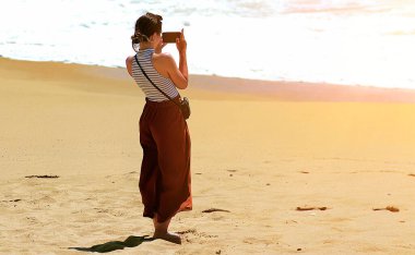 Güneşli bir sabahta kumsalda tek başıma yürüyorum.