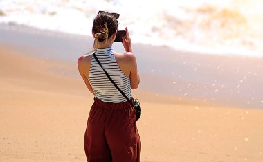 Güneşli bir sabahta kumsalda tek başıma yürüyorum.