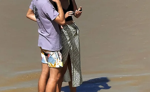 Una Giovane Coppia Che Guarda Cellulare Sulla Spiaggia — Foto Stock