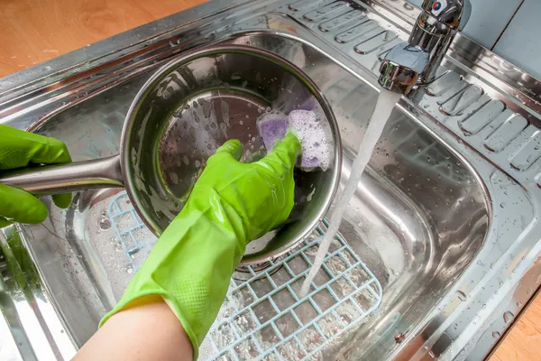 Frau spült Geschirr in der Spüle — Stockfoto