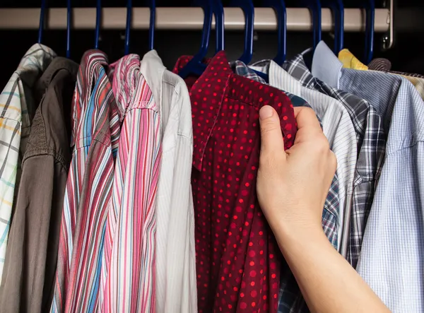 Pessoa escolhe camisa no armário — Fotografia de Stock