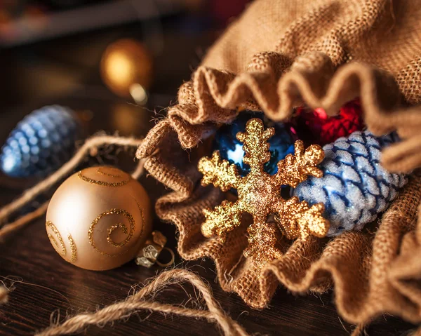 Christmas decorations spilled from canvas bag on a table — Stock Photo, Image