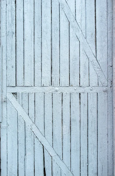 Alte, farbige Farbe, rissige Holztür mit diagonalen Lamellen — Stockfoto