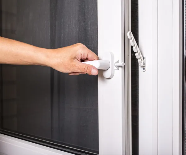 Man opens pvc window with mosquito strainer — Stock Photo, Image