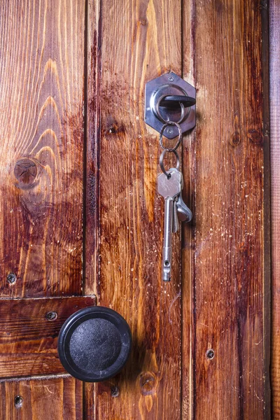 Vieille porte en bois avec clé insérée dans la serrure — Photo
