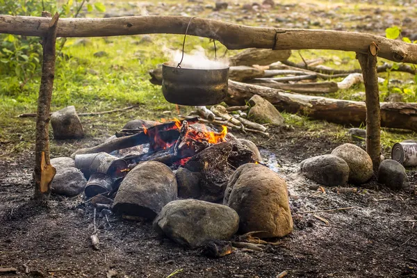 Приготування їжі в поході в котел, що звисає над вогнем — стокове фото